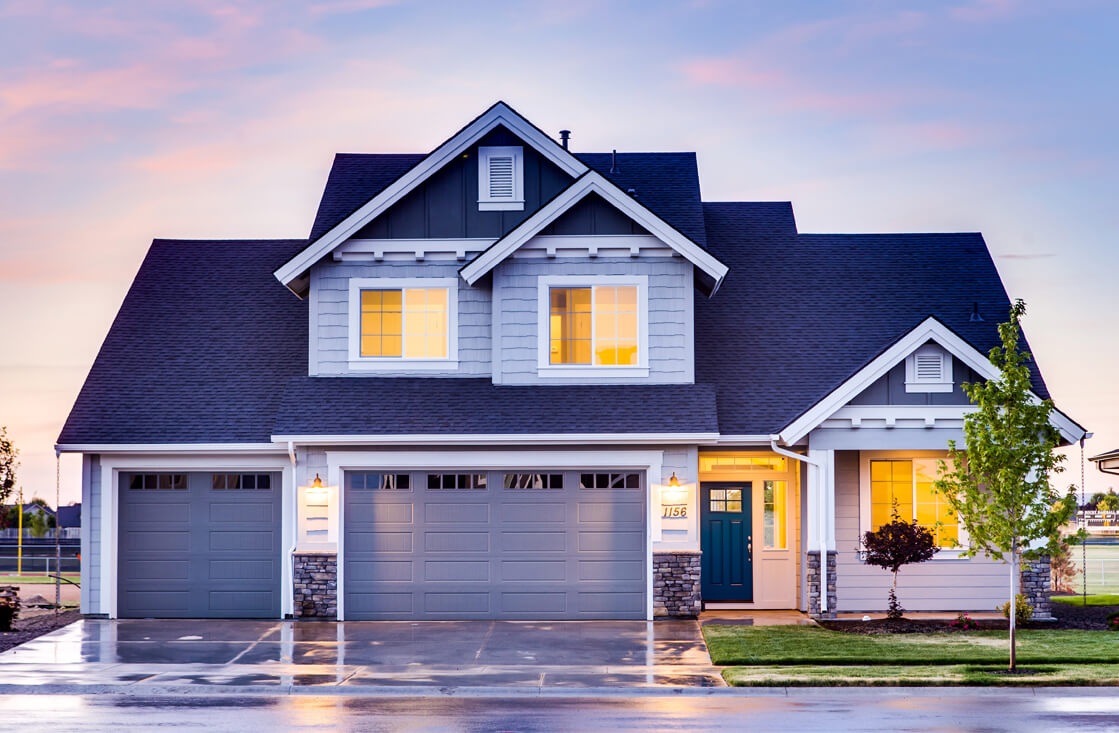 A house with a driveway and garage in front of it.