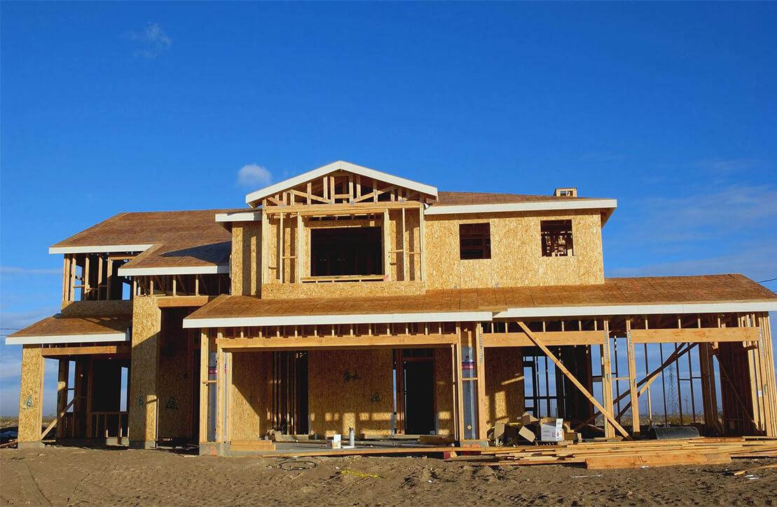 A house under construction with some wood on the front.