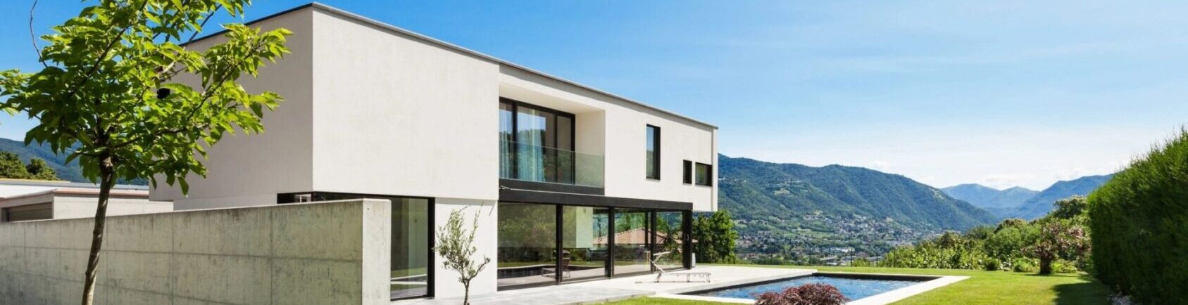 A large white house with glass windows and sliding doors.